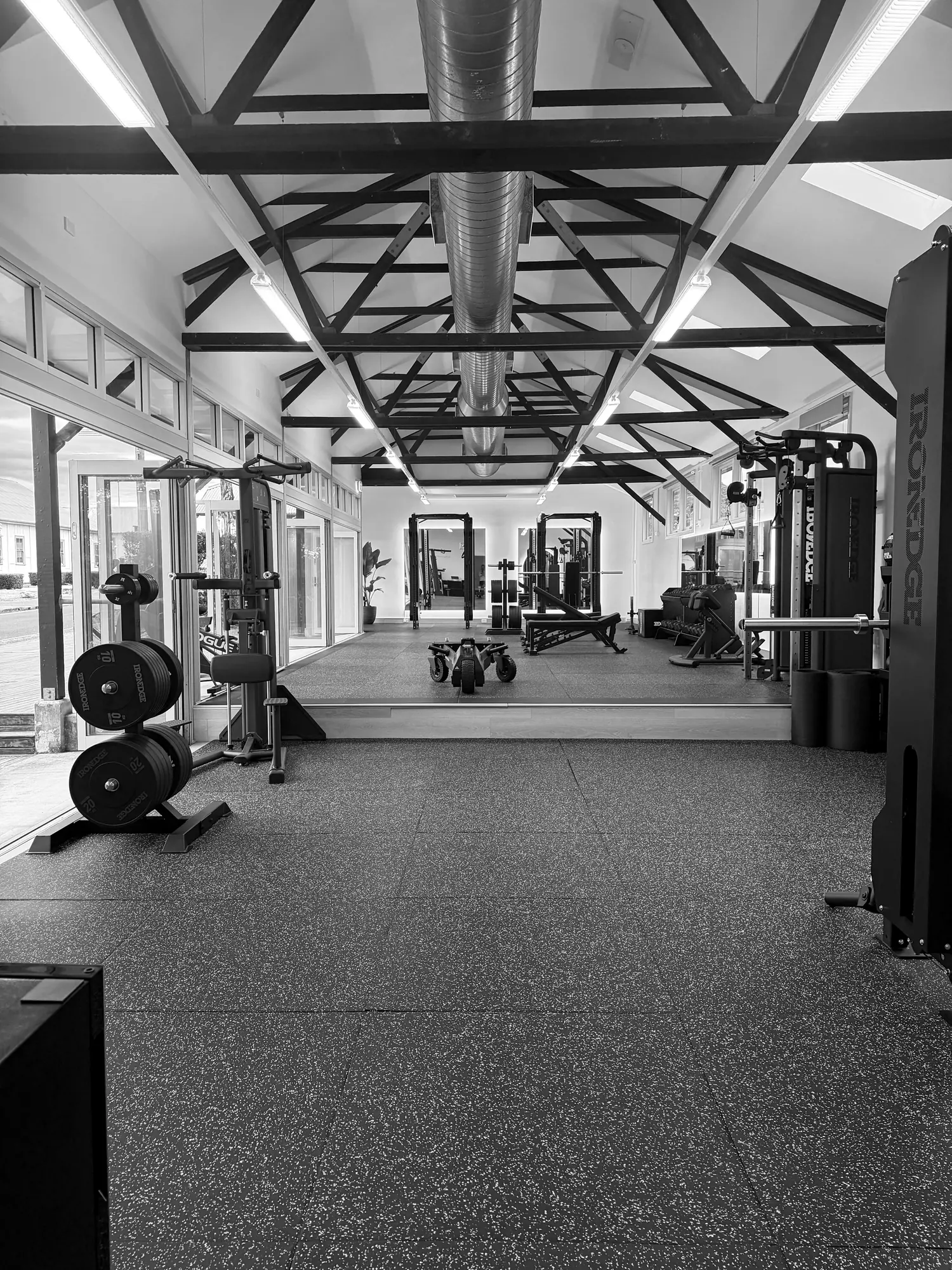 Full view down the Headland Strength and Performance studio, showing the timber truss ceiling and full equipment layout